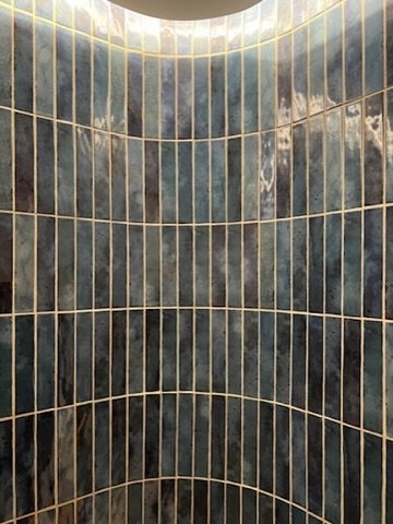 Green glazed tiles, curved shower wall