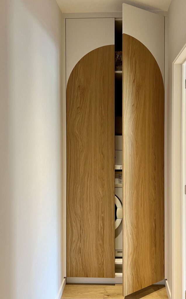 Arched oak door opening onto the laundry