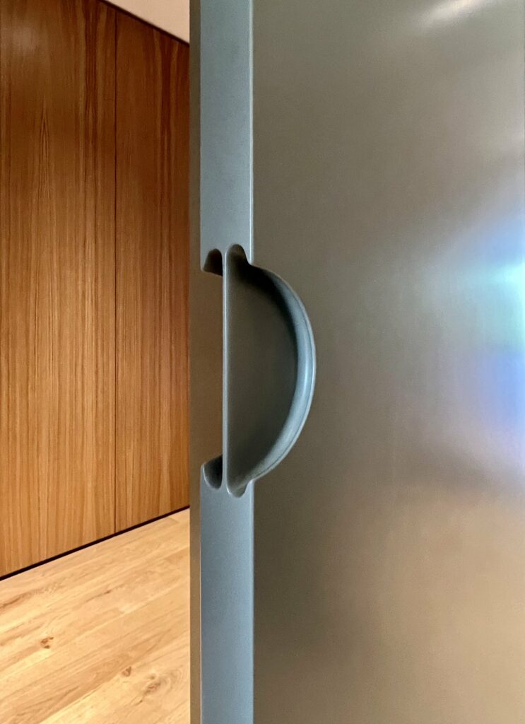 Detail of a recessed handle in sage green
