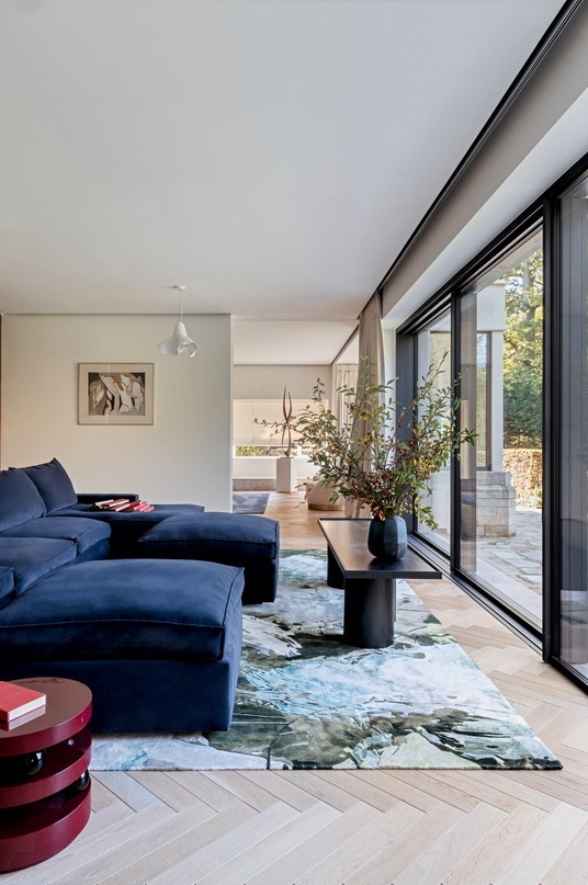 Steel coffee table by the glazing, garden beyond