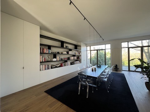 Bespoke black-shelved library between two full-height white cupboards, dining room