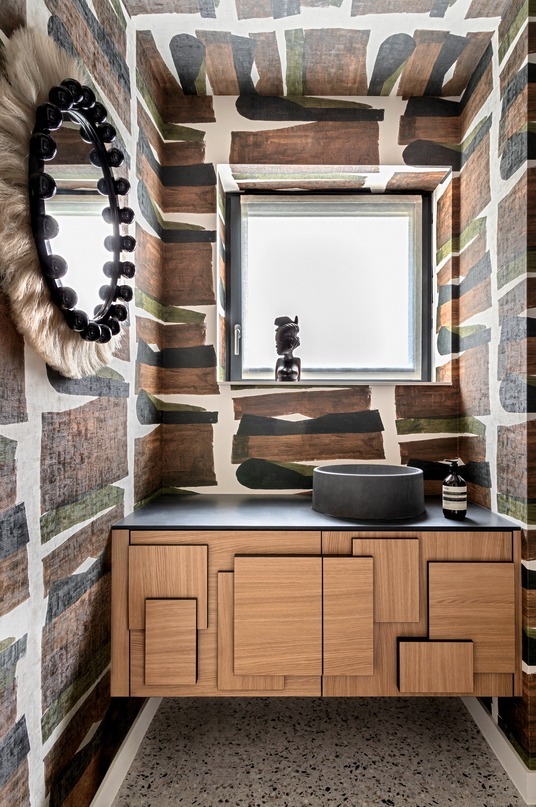 Oak vanity unit with relief fronts in a cloakroom with painted wallpaper, round concrete basin